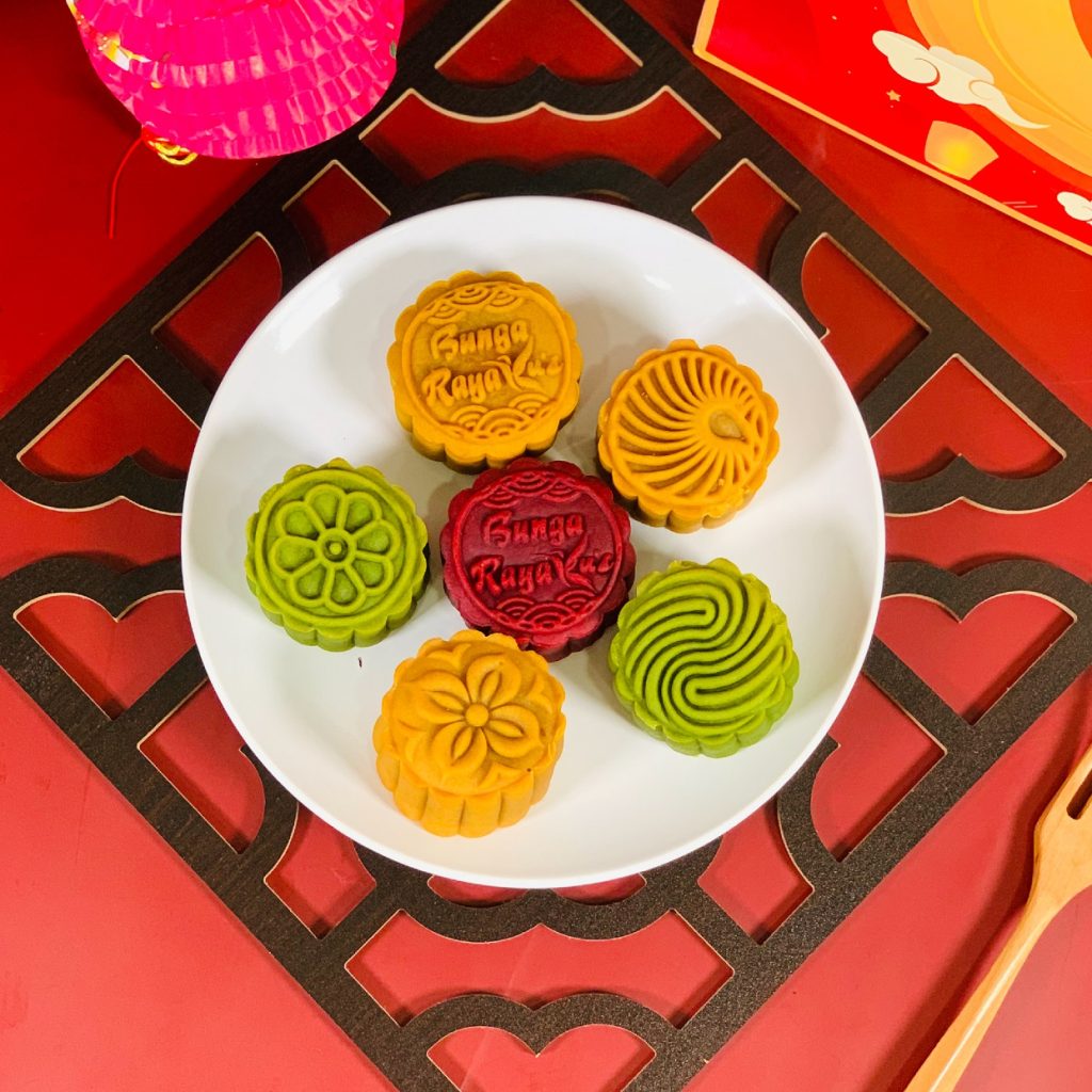 this picture contains image of 6 pcs of Mooncake with different flaovurs on the plate and have some decorations.