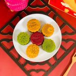 this picture contains image of 6 pcs of Mooncake with different flaovurs on the plate and have some decorations.