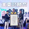 The image is decorative, its contains image of 3 people holding on one certificate of the program on the stage.